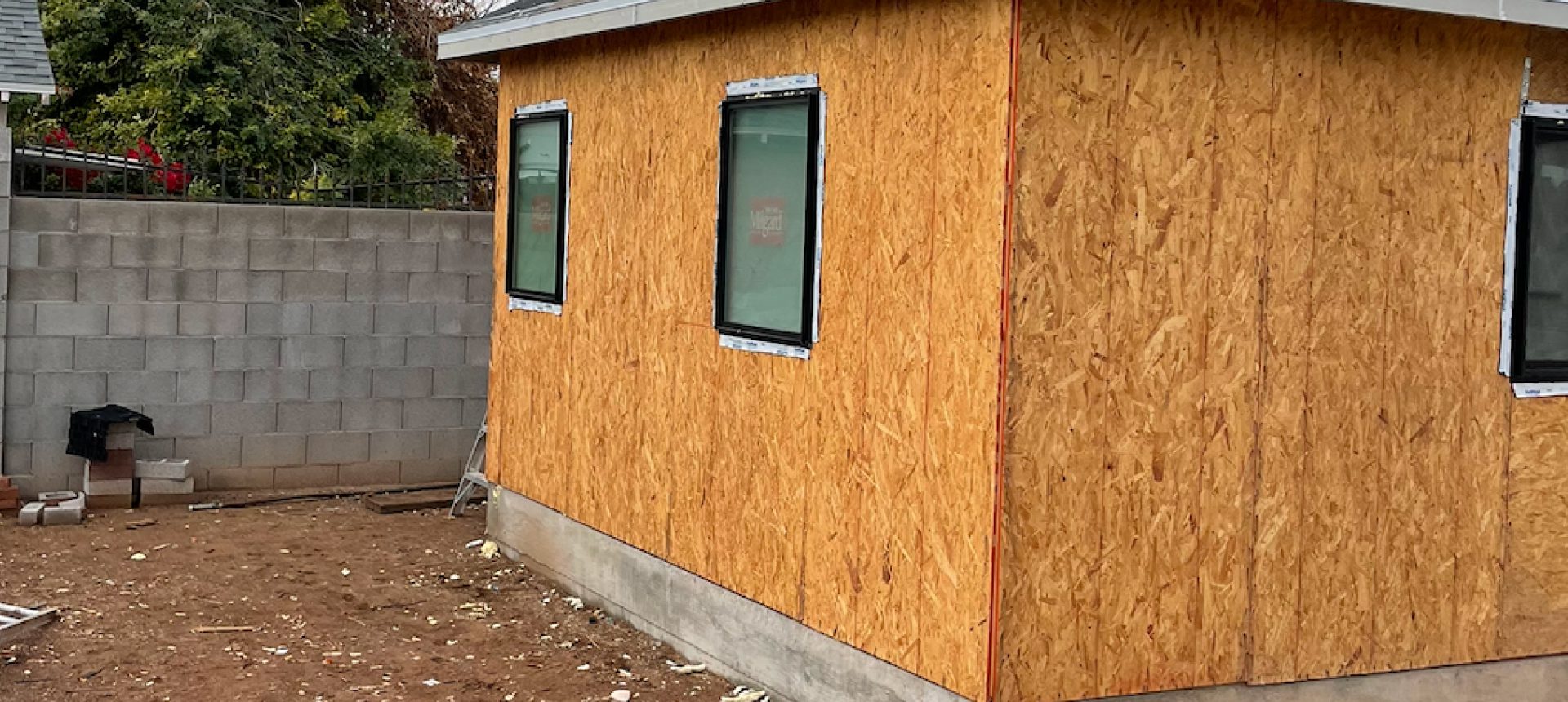 Newly installed plywood siding on a building under construction.