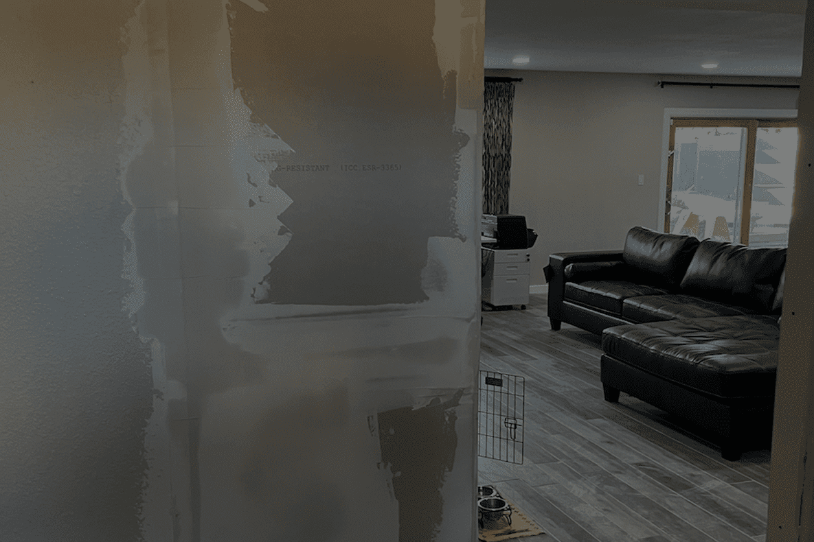 A partially finished wall with drywall mud in a modern living room.