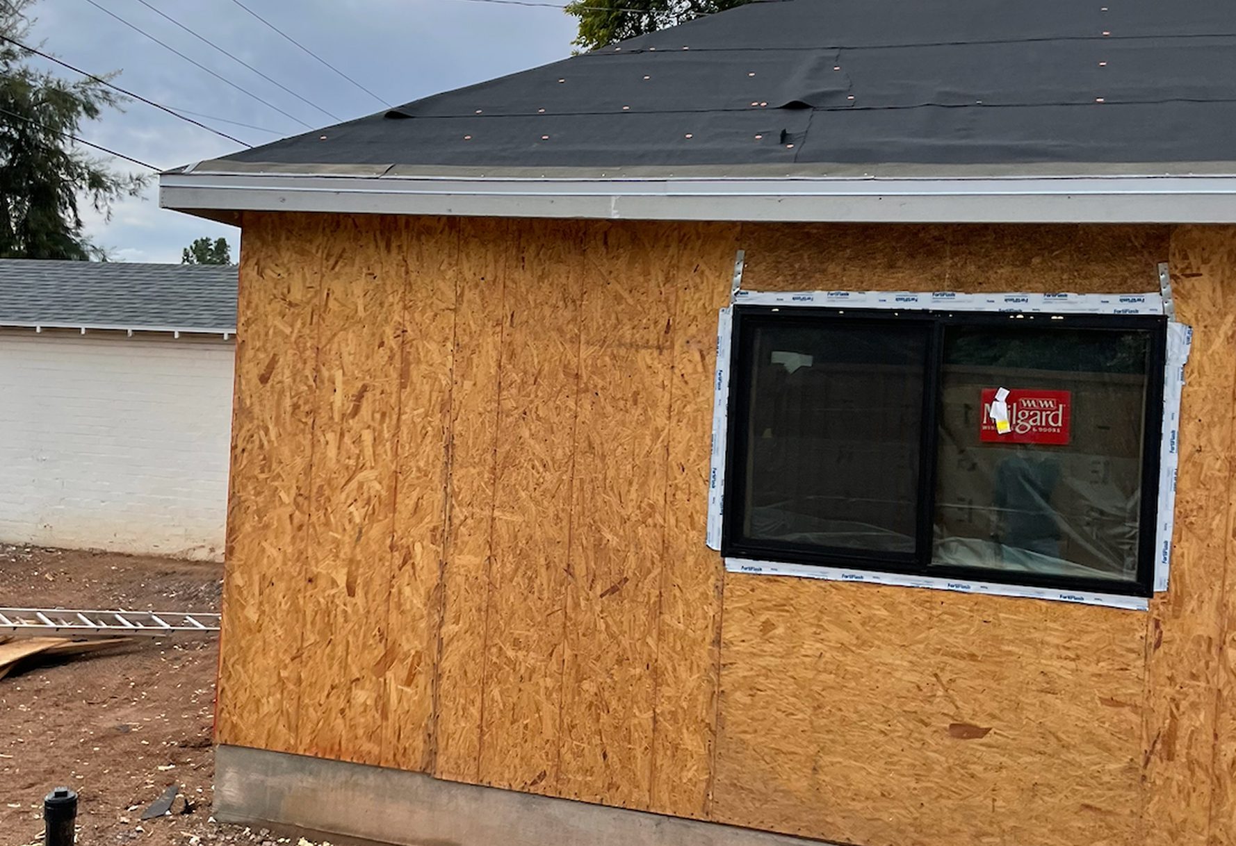 A wooden structure with a black roof and a small window.